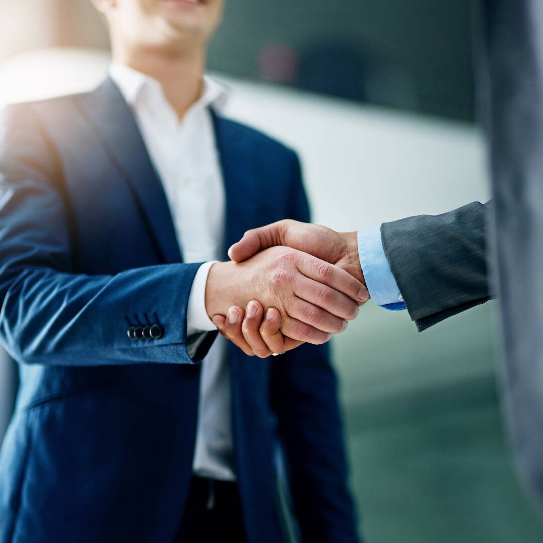 Two men in business suits shaking hands